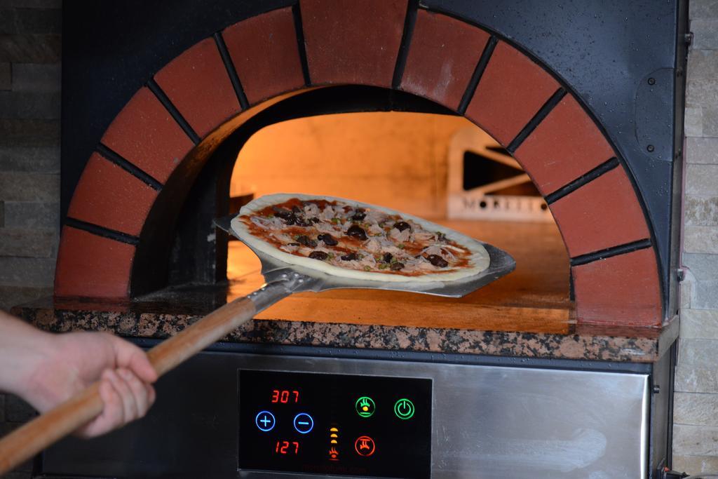 Symphony Style Hotel Kuwait Salmiya Екстериор снимка Pizza being removed from a wood-fired oven
